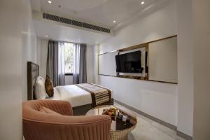 a hotel room with a bed and a tv at Hotel Kaca Inn-by Haveliya Hotels in New Delhi