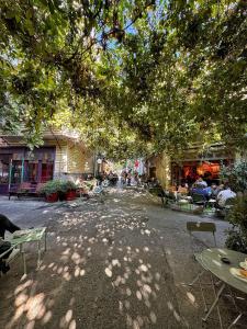 una calle sombreada con mesas y sillas bajo un árbol en Nomad Hostel Karaköy, en Estambul