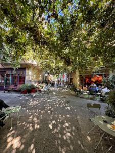 a shady street with tables and chairs under a tree at Nomad Hostel Karaköy in Istanbul