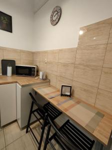 cocina con mesa, 2 sillas y microondas en LittleRoom, en Lublin