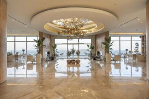 a large lobby with a chandelier and tables and chairs at Del Mare Reserve Hotel & Spa Bodrum in Bodrum City