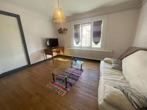 a living room with a couch and a table at Maison avec jardin proximité gare in Tonneins