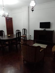 a dining room with a table and chairs and a television at Cómo en casa in Rosario