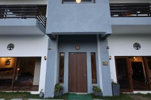 a white house with a wooden door and stairs at villa 33 in Kasauli +2 photos