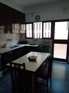 eine Küche mit einem Tisch und Stühlen sowie einem Tisch und einem Tisch mit einem Stuhl in der Unterkunft Cómo en casa in Rosario