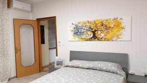 1 dormitorio con 1 cama y una pintura en la pared en 20 VENTI, en Angolo Terme