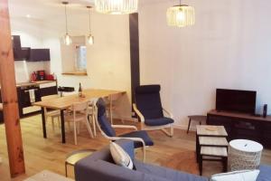un soggiorno con divano, tavolo e sedie di Cœur de ville, spacieux appartement rez de jardin a Paimpol
