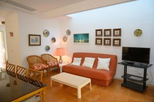 uma sala de estar com um sofá e uma televisão em La casa de la Bahía em Puerto de Mazarrón
