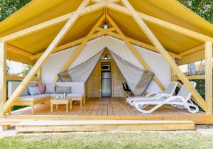 namiot z kanapą i krzesłami na tarasie w obiekcie Camping Marelago w Caorle