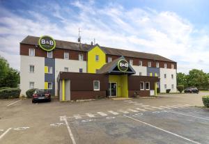 un grande edificio con un parcheggio antistante di B&B HOTEL Beaune Sud 2 a Beaune