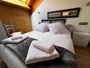 a bedroom with a white bed with towels on it at Duplex en Casco Histórico in León