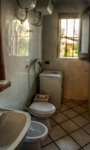 een badkamer met een toilet, een wastafel en een raam bij Casale il Pozzo in Sciacca