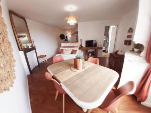 een woonkamer met een houten tafel en roze stoelen bij Appt à 5 min de Barbizon - 15 min de Fontainebleau in Perthes-en-Gâtinais