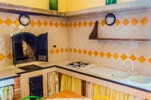 een keuken met een fornuis en een wastafel bij Casale il Pozzo in Sciacca