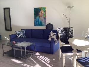a living room with a blue couch and a table at SylviaBo i Skien sentrum in Skien