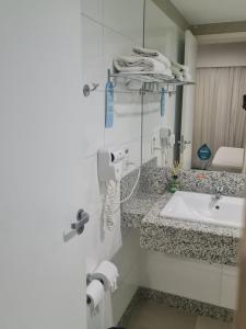 a bathroom with a sink and a counter top at Suites Pampulha Hotel in Belo Horizonte