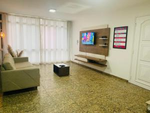 un soggiorno con divano e TV a schermo piatto di Sobrado Amplo ( 5 min Hosp. Eintein) a San Paolo
