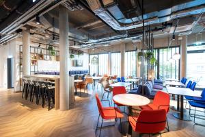 a restaurant with tables and chairs and windows at LOGINN Hotel Waiblingen in Waiblingen