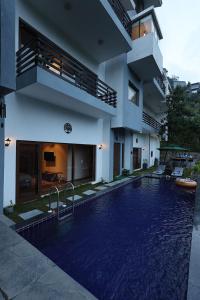 a house with a swimming pool in front of a building at villa 33 in Kasauli