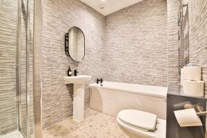 a bathroom with a toilet and a sink and a tub at The Kingsway- 2 Bedroom Central Swansea Apartments By StayRight in Swansea