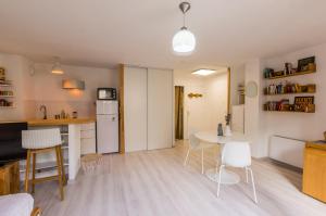 Il comprend une cuisine et un salon avec une table et des chaises. dans l'établissement La Domitienne - Premiere conciergerie, à Montpellier