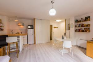 a kitchen and living room with a table and chairs at La Domitienne - Premiere conciergerie in Montpellier