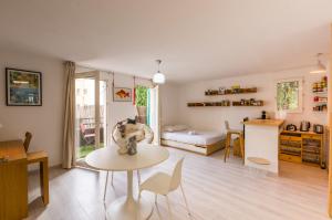 a large living room with a table and a kitchen at La Domitienne - Premiere conciergerie in Montpellier