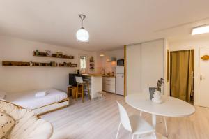 een woonkamer met een bed en een tafel bij La Domitienne - Premiere conciergerie in Montpellier
