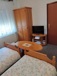 a room with two beds and a table and a desk at Prenoćište San Rooms in Livno