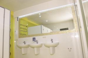 a bathroom with three sinks and a mirror at Demeevsky Hostel in Kyiv +33 photos