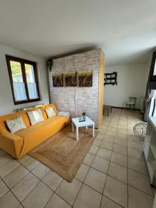 ein Wohnzimmer mit einem Sofa und einem Tisch in der Unterkunft Casa Nonna Elide 2 in Besozzo