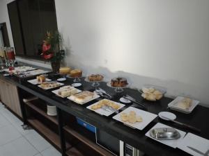 una línea de buffet con diferentes tipos de comida. en Gurgueia Park Hotel, en Cristino Castro
