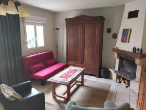 ein Wohnzimmer mit einem roten Sofa und einem Kamin in der Unterkunft Logis51 in Ville-sur-Tourbe