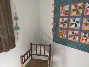 a wooden chair and a quilt hanging on a wall at Logis51 in Ville-sur-Tourbe