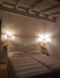 um quarto com uma cama grande e 2 lustres em Olive -Casa da Boavista em Alegrete