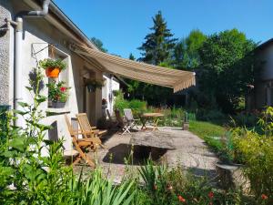 a patio with chairs and a table in a yard at Logis51 in Ville-sur-Tourbe