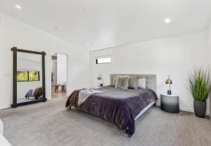 a white bedroom with a bed and a large mirror at Modern Luxury Home in the Heart of West Sedona in Sedona