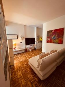 een woonkamer met een bank en een televisie bij Appartamento Camilla in Ferrara
