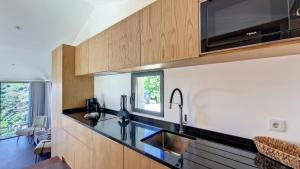 una cocina con fregadero y microondas en Serenity Valley Escape by LovelyStay, en Ribeira Brava