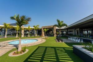 um resort com piscina, palmeiras e um edifício em 864 Ballito Hillis Luxury Estate Family Apartment em Ballito