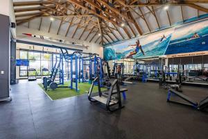 a gym with several tread machines and a large mural at 864 Ballito Hillis Luxury Estate Family Apartment in Ballito