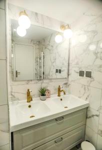 a white bathroom with a sink and a mirror at Exquisite tiny house with garden and air con - between Paris-Disneyland - 3mins from train station in Noisy-le-Grand