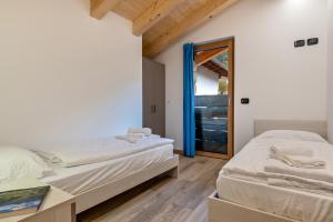 ein Schlafzimmer mit zwei Betten und einem Spiegel in der Unterkunft Tobià de Pit in Soraga