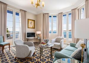 a living room with chairs and a table and a tv at Hôtel Belles Rives in Juan-les-Pins