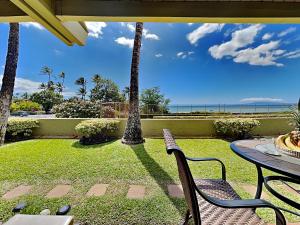 un patio con mesa, sillas y el océano en Shores of Maui 121, en Kihei