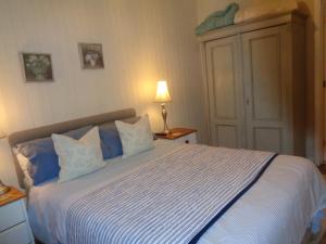 um quarto com uma cama grande com lençóis azuis e brancos em Log Cabin, Conveniently Situated halfway between Stratford and Warwick em Stratford-upon-Avon