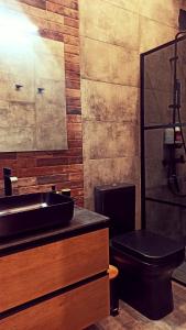 a bathroom with a black toilet and a sink at Stay in Athens - muses in Athens +18 photos