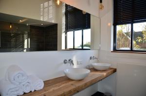a bathroom with two sinks and a large mirror at Kerkje van Peins in Peins