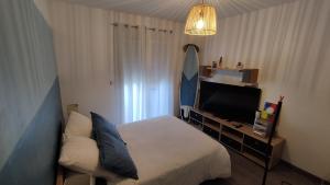 een hotelkamer met een bed en een televisie bij Maison contemporaine à Artigues-près-Bordeaux in Artigues-près-Bordeaux