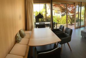 einen Konferenzraum mit einem Tisch, Stühlen und einem Klavier in der Unterkunft Ahornlounge Faoug am Murtensee in Faoug